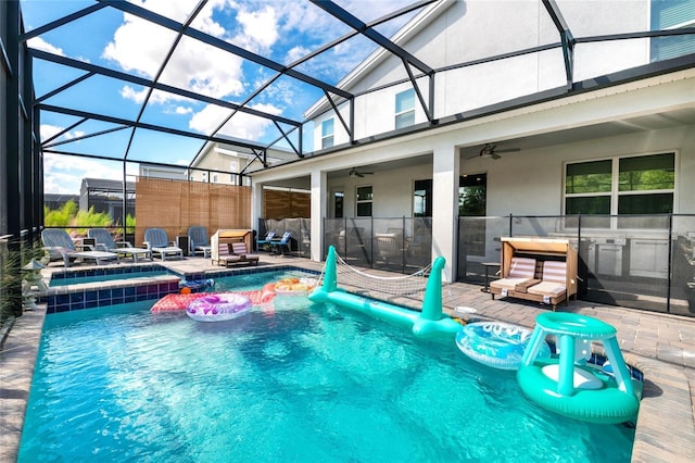 view of pool featuring ceiling fan, a patio, and glass enclosure