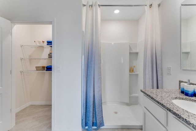 bathroom with walk in shower and vanity