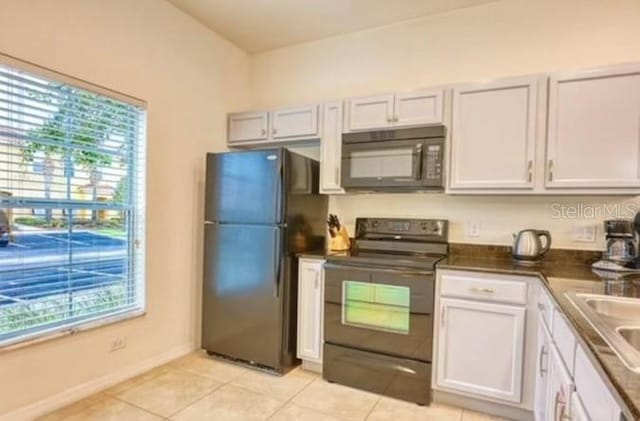 kitchen featuring white cabinetry, light tile patterned floors, black appliances, and sink