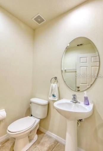 bathroom featuring toilet and tile patterned flooring