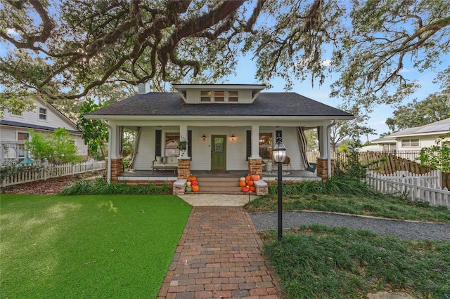 view of front of home featuring covered porch and a front yard