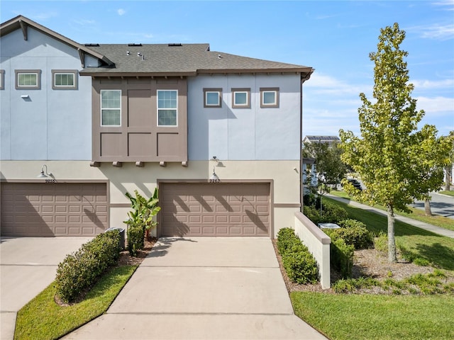 view of front of home featuring stucco siding, driveway, and a shingled roof