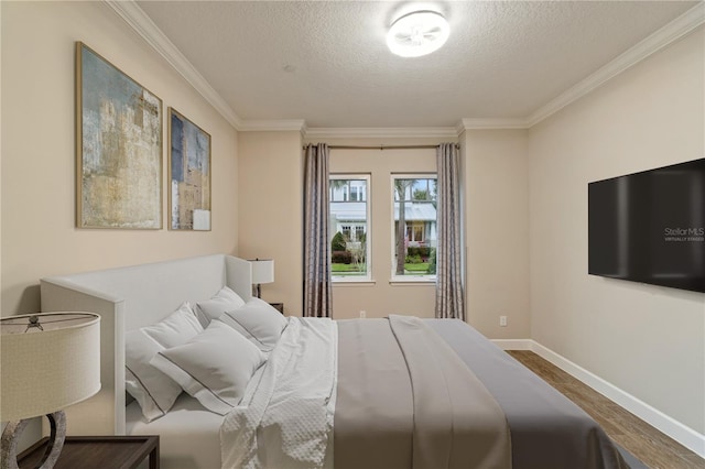 bedroom with crown molding, wood finished floors, baseboards, and a textured ceiling