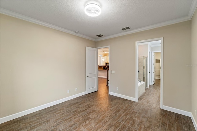 unfurnished bedroom with wood-type flooring, a textured ceiling, and ornamental molding