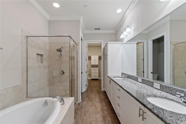 full bathroom with a shower stall, ornamental molding, and a sink