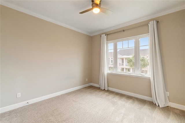 carpeted spare room featuring ceiling fan and ornamental molding