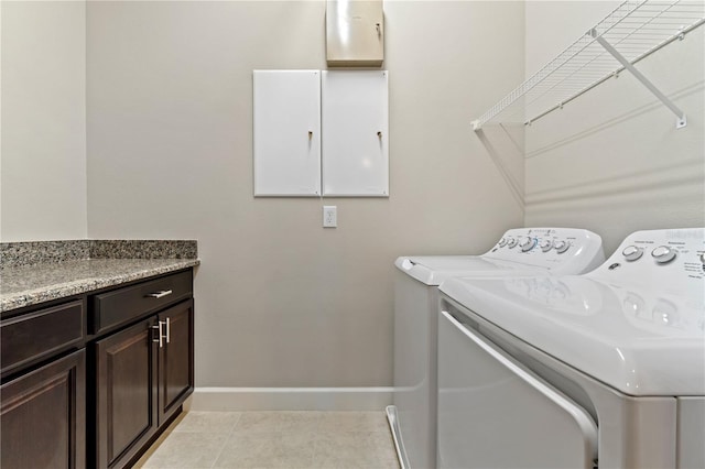 laundry room featuring light tile patterned floors, independent washer and dryer, cabinet space, and baseboards