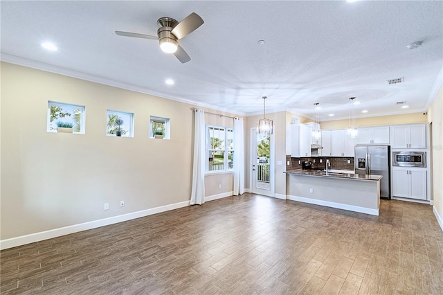 unfurnished living room featuring visible vents, ceiling fan, ornamental molding, dark wood-style floors, and a sink