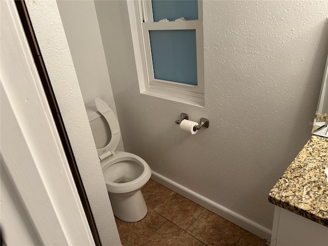 bathroom featuring vanity, tile patterned floors, and toilet