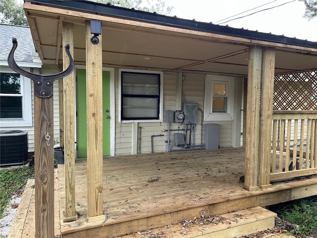 property entrance with central AC unit and a deck