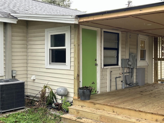 entrance to property featuring central air condition unit and a wooden deck