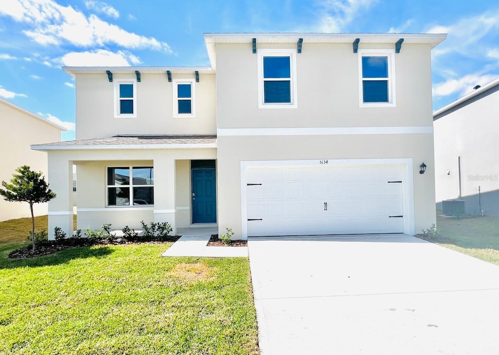 view of front of house featuring a garage and a front lawn