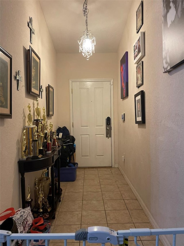 doorway featuring tile patterned flooring and an inviting chandelier