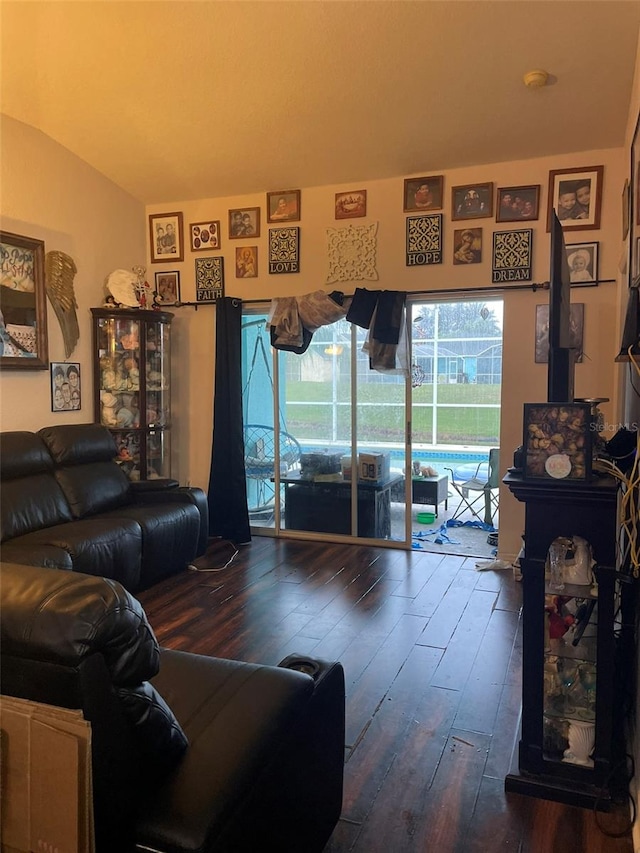 living room with dark hardwood / wood-style flooring and vaulted ceiling