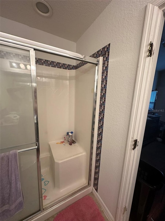 bathroom featuring a shower with shower door