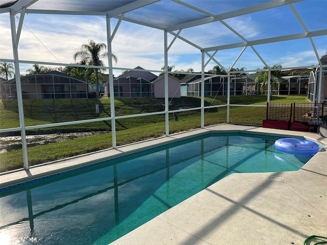 view of swimming pool with glass enclosure, a lawn, and a patio area