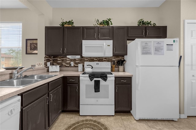 kitchen with white appliances, dark brown cabinetry, and sink