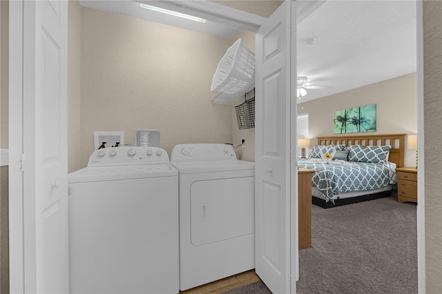 laundry area with washer and clothes dryer, ceiling fan, and light carpet