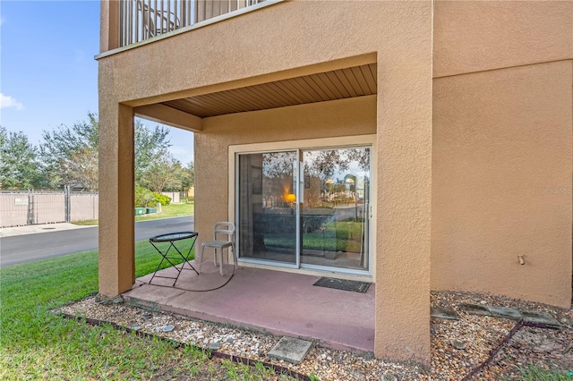 property entrance with a yard and a balcony