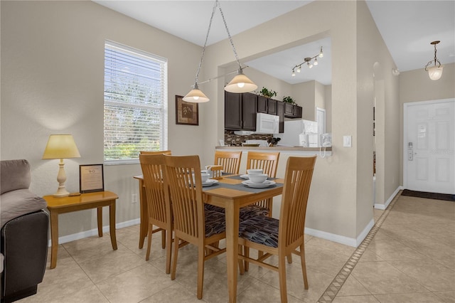 tiled dining room featuring vaulted ceiling