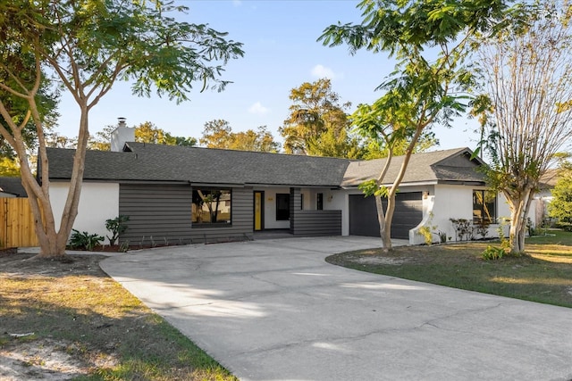 ranch-style house with a garage and a front lawn