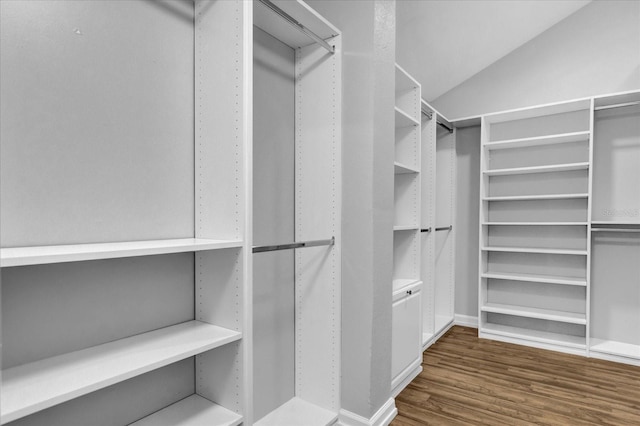 walk in closet with dark hardwood / wood-style flooring and lofted ceiling