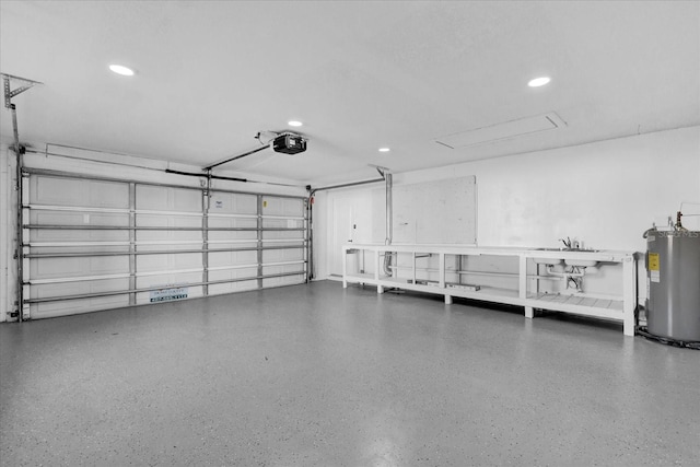 garage featuring water heater, sink, and a garage door opener