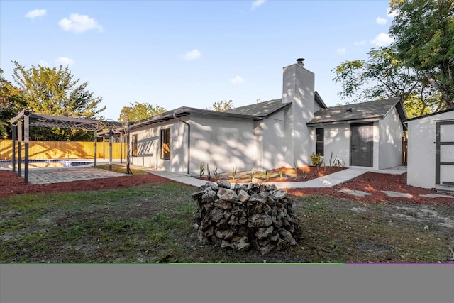 back of property featuring a yard, a patio, and a storage shed