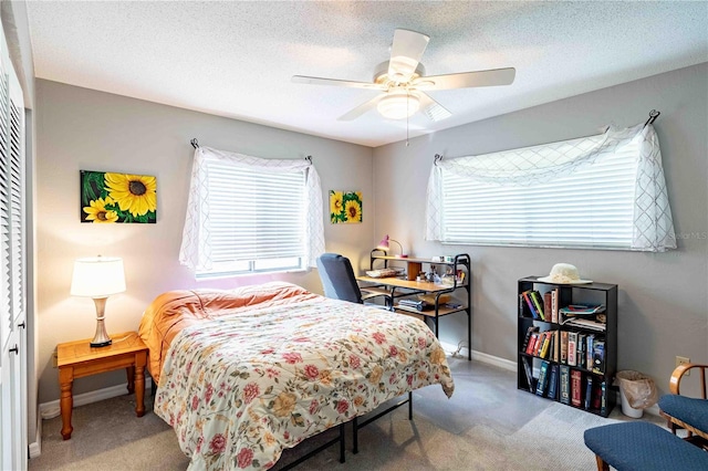 bedroom with a textured ceiling, carpet floors, a closet, and ceiling fan