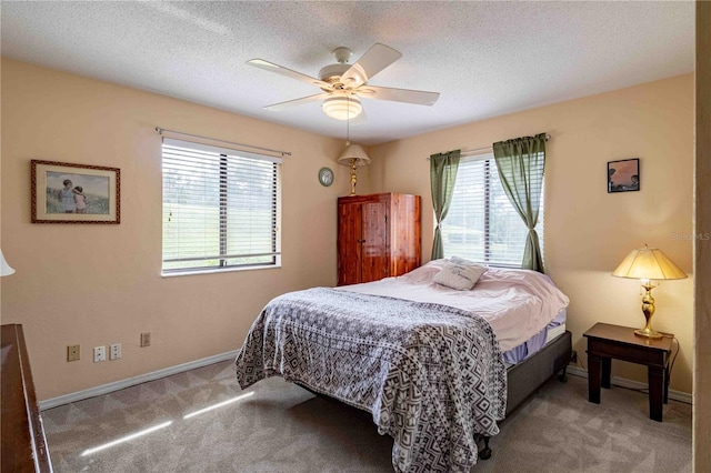 bedroom with carpet flooring, ceiling fan, and a textured ceiling