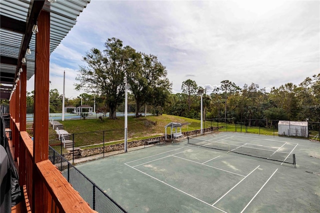 view of tennis court with a yard