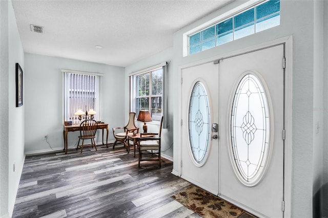 foyer entrance with wood-type flooring and a textured ceiling