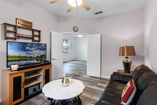 living room featuring hardwood / wood-style flooring and ceiling fan