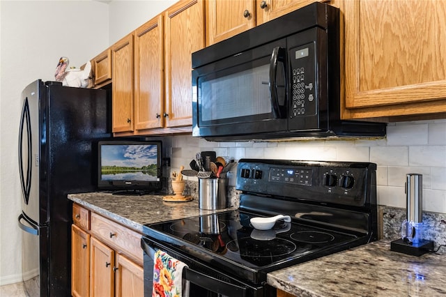 kitchen featuring dark stone countertops, black appliances, and decorative backsplash