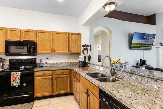 kitchen with black appliances, light tile patterned floors, sink, backsplash, and light stone countertops