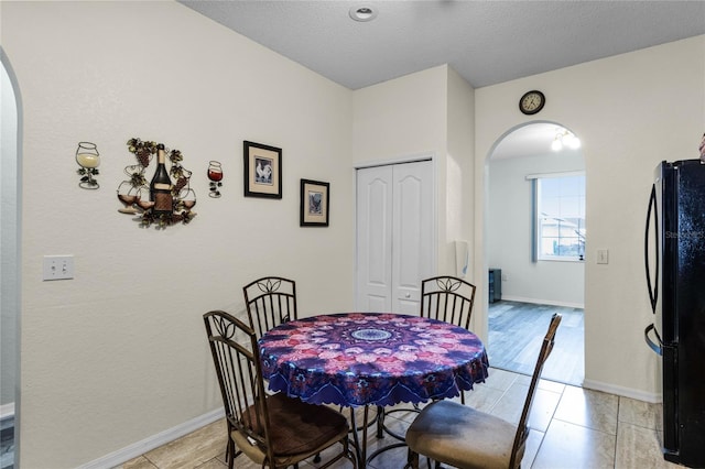 dining room with a textured ceiling and light tile patterned floors