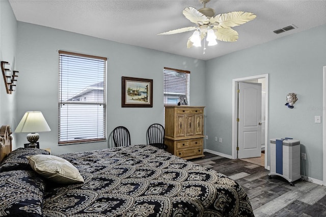 bedroom with dark wood-type flooring, a textured ceiling, and ceiling fan