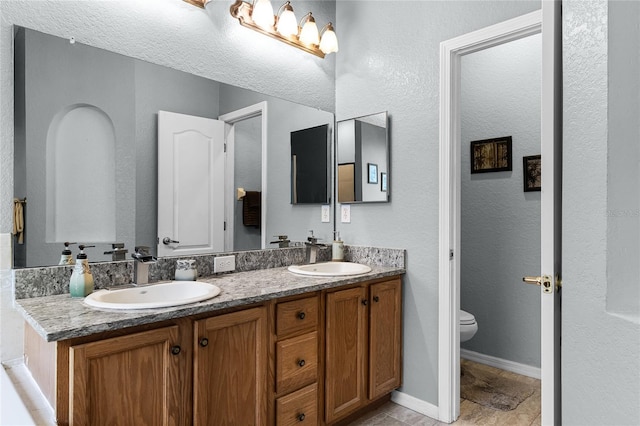 bathroom featuring tile patterned floors, vanity, and toilet