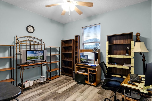 office space with a textured ceiling, light wood-type flooring, and ceiling fan