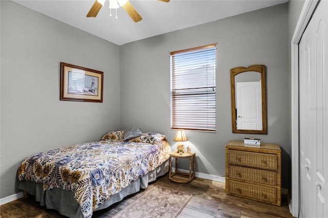 bedroom featuring hardwood / wood-style flooring, ceiling fan, and a closet