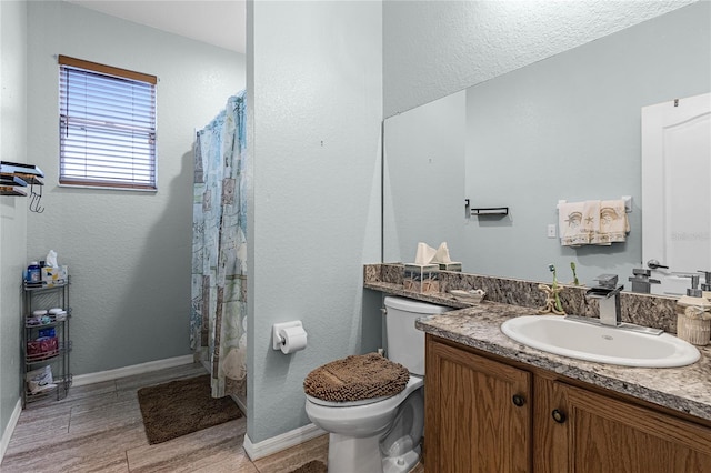 bathroom with toilet, vanity, and wood-type flooring