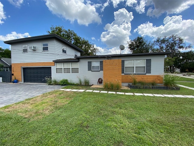 view of front of property featuring a garage, an AC wall unit, and a front yard