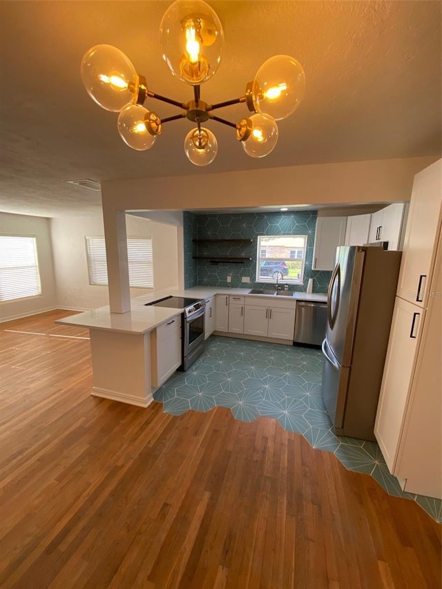 kitchen featuring stainless steel appliances, tasteful backsplash, sink, and white cabinets