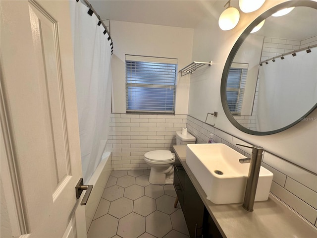 full bathroom with shower / tub combo with curtain, toilet, tile walls, vanity, and tile patterned flooring