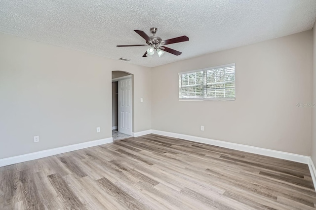 spare room featuring ceiling fan, a textured ceiling, and light wood-type flooring