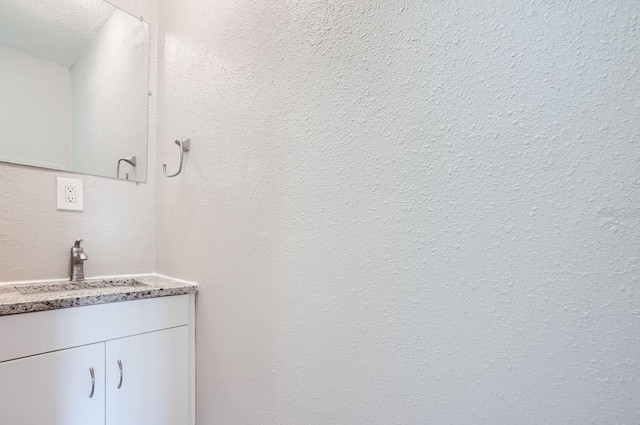 bathroom with vanity and a textured ceiling