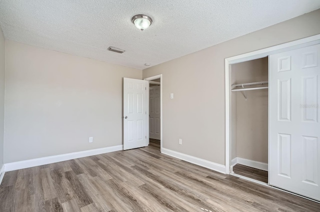 11335 Pickford St, Spring Hill, FL 34609 - unfurnished bedroom with wood finished floors, a closet, a textured ceiling, and baseboards