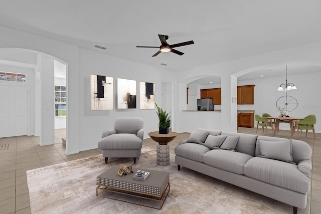 living room featuring light tile patterned floors and ceiling fan with notable chandelier