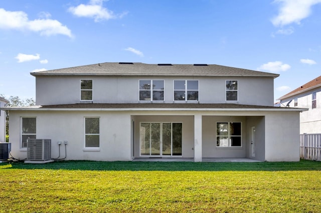 rear view of property featuring central air condition unit, a patio area, and a yard