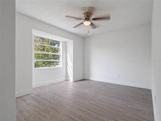 spare room featuring ceiling fan, wood-type flooring, and a textured ceiling